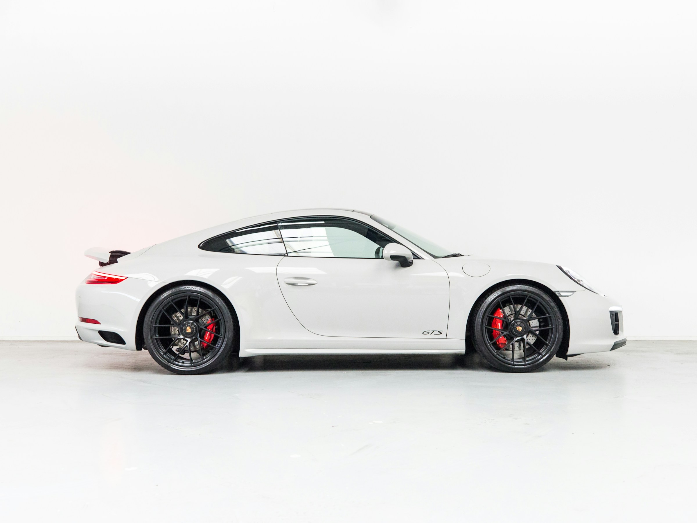 Stock white Porsche 911 Carrera 4 GTS photographed in a studio